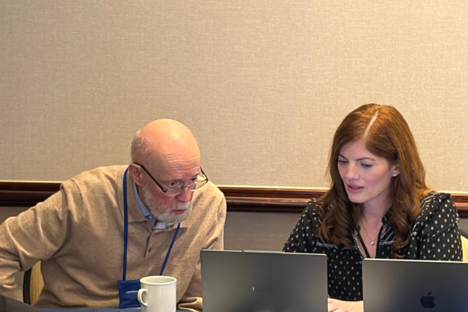 Jim Womack at a laptop with a colleague, working a problem with AI